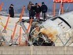 Investigators, including officials from South Korea's Aviation and Railway Accident Investigation Board (ARAIB), US National Transportation Safety Board (NTSB) and aircraft manufacturer Boeing, stand by the mound where the instrument landing system localiser is located, at the scene where a Jeju Air Boeing 737-800 aircraft crashed and burst into flames at Muan International Airport.