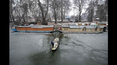 A man breaks the ice as he rows his boat on the partially frozen Dal Lake in Srinagar on December 31. (AFP) A man breaks the ice as he rows his boat on the partially frozen Dal Lake in Srinagar on December 31. (AFP)