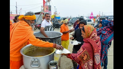 Pilgrims receive food ahead of Mahakumbh 2025, at Sangam in Prayagraj on Tuesday (PTI) Pilgrims receive food ahead of Mahakumbh 2025, at Sangam in Prayagraj on Tuesday (PTI)