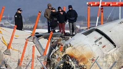 Investigators, including officials from South Korea's Aviation and Railway Accident Investigation Board (ARAIB), US National Transportation Safety Board (NTSB) and aircraft manufacturer Boeing, stand by the mound where the instrument landing system localiser is located, at the scene where a Jeju Air Boeing 737-800 aircraft crashed and burst into flames at Muan International Airport. (AFP) Investigators, including officials from South Korea's Aviation and Railway Accident Investigation Board (ARAIB), US National Transportation Safety Board (NTSB) and aircraft manufacturer Boeing, stand by the mound where the instrument landing system localiser is located, at the scene where a Jeju Air Boeing 737-800 aircraft crashed and burst into flames at Muan International Airport. (AFP)