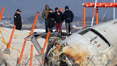 Investigators, including officials from South Korea's Aviation and Railway Accident Investigation Board (ARAIB), US National Transportation Safety Board (NTSB) and aircraft manufacturer Boeing, stand by the mound where the instrument landing system localiser is located, at the scene where a Jeju Air Boeing 737-800 aircraft crashed and burst into flames at Muan International Airport. (AFP) Investigators, including officials from South Korea's Aviation and Railway Accident Investigation Board (ARAIB), US National Transportation Safety Board (NTSB) and aircraft manufacturer Boeing, stand by the mound where the instrument landing system localiser is located, at the scene where a Jeju Air Boeing 737-800 aircraft crashed and burst into flames at Muan International Airport. (AFP)