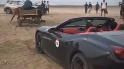 A Ferrari California stranded on Revdanda Beach was amusingly rescued by a bullock cart. (X/ @lordujjwal7) A Ferrari California stranded on Revdanda Beach was amusingly rescued by a bullock cart. (X/ @lordujjwal7)