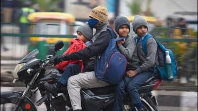 Students braving the cold on their way to school near Delhi-Gurugram border on Tuesday. (Parveen Kumar/Hindustan Times)