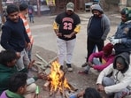 Homeless people sitting around a bonfire to protect themselves from winter on a cold weather Homeless people sitting around a bonfire to protect themselves from winter on a cold weather