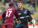 West Indies captain Dwayne Bravo (left) congratulates Corey Anderson after the left-handed batter scored a century in an ODI match in Queenstown.