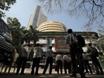 People look at a screen displaying the Sensex results on the facade of the Bombay Stock Exchange (BSE) building in Mumbai.