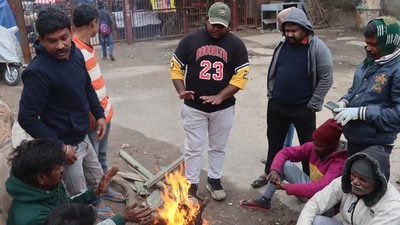 Homeless people sitting around a bonfire to protect themselves from winter on a cold weather