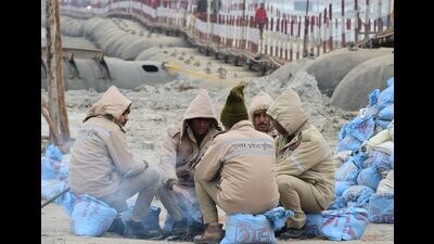 A group of policemen crowd around a small bonfire to beat the cold in Mela area on a chilly and foggy day on the banks of Sangam in Prayagraj on Wednesday. (Anil Kumar Maurya/HT) A group of policemen crowd around a small bonfire to beat the cold in Mela area on a chilly and foggy day on the banks of Sangam in Prayagraj on Wednesday. (Anil Kumar Maurya/HT)