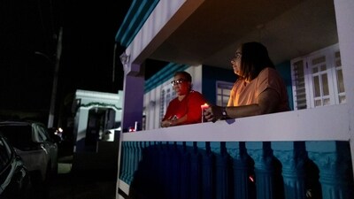 Residents hold candles on New Year's Eve during a blackout (Bloomberg) Residents hold candles on New Year's Eve during a blackout (Bloomberg)