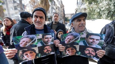 Protesters gather for a vigil seeking information about Syrian activists who were abducted by unidentified assailants in December 2013, in Douma on the eastern outskirts of Damascus on January 1, 2025. (AFP) Protesters gather for a vigil seeking information about Syrian activists who were abducted by unidentified assailants in December 2013, in Douma on the eastern outskirts of Damascus on January 1, 2025. (AFP)