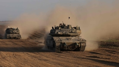 An Israeli soldier gestures from the top of army vehicle near the Israeli border fence with the Gaza Strip on December 10, 2024, as the war between Israel and Hamas continues in Gaza.&nbsp; (AFP/Menahem Kahana)