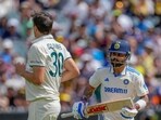 India's Virat Kohli run between the wickets to score as Australia's captain Pat Cummins looks on.
