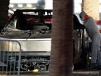 The remains of a Tesla Cybertruck that burned at the entrance of Trump Tower are inspected in Las Vegas, Nevada, US, on January 1, 2025.  