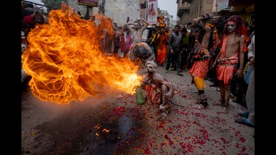A Panchayati Mahanirvani Akhara devotee performs fire breathing stunts in a procession towards the Sangam, the confluence of rivers Ganges and Yamuna (AP)
