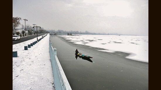 A man rows his boat on a frozen Dal Lake after light snowfall in Srinagar on Thursday. (Waseem Andrabi/HT)