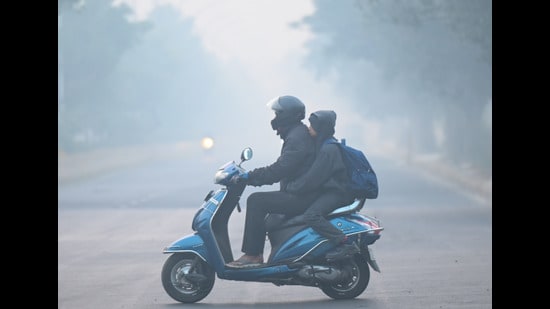School children going to school amid severe cold and dense fog in Noida Sector 25. School timings changed in Gautam Budh Nagar due to increasing cold. (SUNIL GHOSH/HT)