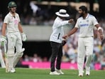 Umpire Sharfuddoula Saikat, centre, gestures to India's Jasprit Bumrah, right, as he exchanges words with Australia's Sam Konstas.