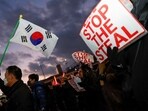 Pro-Yoon protesters hold South Korean flags and 'STOP THE STEAL' signs during a rally near impeached South Korean President Yoon Suk Yeol's official residence