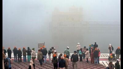 Devotees paying obeisance amid dense fog at the Golden Temple in Amritsar on Friday. (HT Photo)
