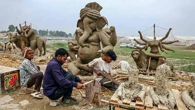 People work on idols of deities along a roadside, ahead of the Maha Kumbh Mela in Prayagraj. (AFP)
