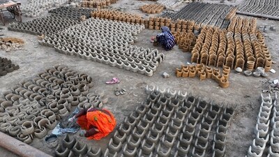 Women make clay stoves to be sold to the devotees who will be staying on the banks of the Ganga. (AP)