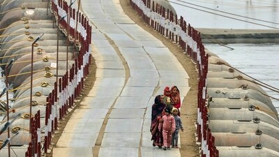 Women and children walk over a floating pontoon bridge across river Ganges, on a cold winter afternoon, ahead of the Maha Kumbh Mela festival in Prayagraj. (AFP)
