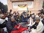 Jan Suraj Party founder Prashant Kishore with party leaders and workers sitting on dharna in protest against lathi charge on students for demanding re-exam in front of statue of Mahatma Gandhi at Gandhi Maidan in Patna, Bihar on Friday (Photo by Santosh Kumar/ Hindustan Times)