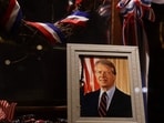 A photograph of President Jimmy Carter sits in the window of a store on the main street of his hometown on January 04, 2025, in Plains, Georgia.  