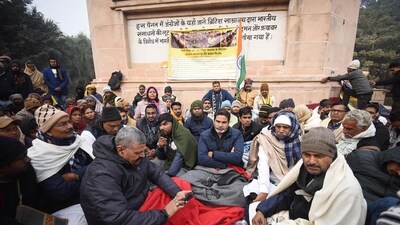 Jan Suraj Party founder Prashant Kishore with party leaders and workers sitting on dharna in protest against lathi charge on students for demanding re-exam in front of statue of Mahatma Gandhi at Gandhi Maidan in Patna, Bihar on Friday (Photo by Santosh Kumar/ Hindustan Times)