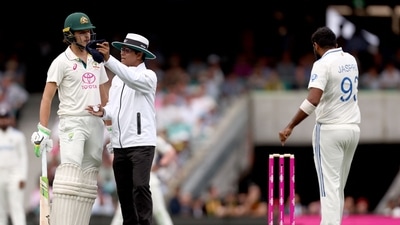 Umpire Sharfuddoula Ibne Shahid Saikat (C) gestures as he stands between Australia's Sam Konstas (L) and India's captain Jasprit Bumrah (R) (AFP)