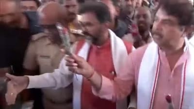 Karnataka opposition leader R Ashoka distributing roses to passengers. Karnataka opposition leader R Ashoka distributing roses to passengers.