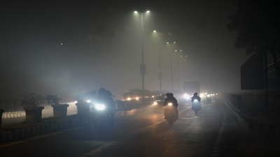 Commuters move along a road on a dense fog at Friday Night, in New Delhi India on January 4. Delhi airport on Saturday saw 19 flight diversions, many cancellations and over 400 flight delays due to fog, a PTI report said. (Hindustan Times)