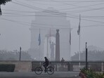A man cycles amid a thin layer of fog on a cold winter morning at India Gate. A man cycles amid a thin layer of fog on a cold winter morning at India Gate.