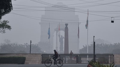 A man cycles amid a thin layer of fog on a cold winter morning at India Gate. (ANI) A man cycles amid a thin layer of fog on a cold winter morning at India Gate. (ANI)