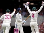 Australia's Marnus Labuschagne (L) and wicketkeeper Alex Carey (R) react as India's Shubman Gill (C) is dismissed during day one of the fifth cricket Test match.