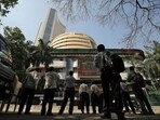 Stock market crash: People look at a screen displaying the Sensex results on the facade of the Bombay Stock Exchange (BSE) building in Mumbai.