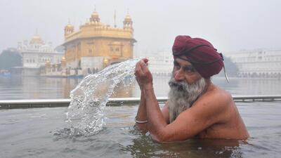 A devotee taking a dip in the holy sarovar (water tank) of the Golden Temple in Amritsar on the occasion of the birth anniversary of Guru Gobind Singh on Monday. (Sameer Sehgal/HT)