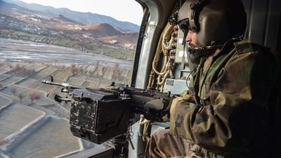 A Taliban security personnel keeps watch from a helicopter two days after air strikes by Pakistan in the Barmal district of eastern Paktika province on December 26. (Ahmad Sahel Arman/AFP) A Taliban security personnel keeps watch from a helicopter two days after air strikes by Pakistan in the Barmal district of eastern Paktika province on December 26. (Ahmad Sahel Arman/AFP)