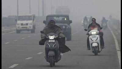 Commuters make their way amid fog in Ludhiana on Monday. (Gurpreet Singh/HT)