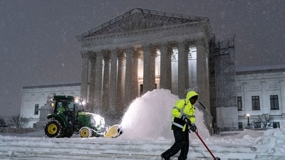 Workers clear snow outside of the US Supreme Court in Washington, DC, US, on Monday, Jan. 6, 2025. Snow is piling up in Washington, shutting down federal offices and schools, as a winter storm that has snarled air and road traffic and knocked out power in six states makes its way east. Photographer: Al Drago/Bloomberg (Bloomberg) Workers clear snow outside of the US Supreme Court in Washington, DC, US, on Monday, Jan. 6, 2025. Snow is piling up in Washington, shutting down federal offices and schools, as a winter storm that has snarled air and road traffic and knocked out power in six states makes its way east. Photographer: Al Drago/Bloomberg (Bloomberg)