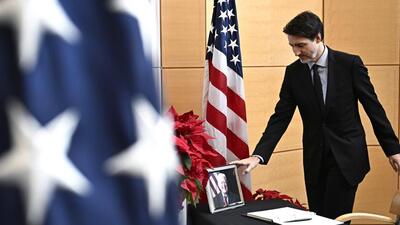 Prime Minister Justin Trudeau touches a photo of former US President Jimmy Carter after signing a book of condolences at the US Embassy in Ottawa, on Friday. (AP) Prime Minister Justin Trudeau touches a photo of former US President Jimmy Carter after signing a book of condolences at the US Embassy in Ottawa, on Friday. (AP)