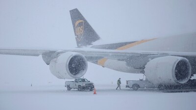 An aeroplane stands amidst severe snowfall. Travel was thrown off gear as more than two feet of snow was reported in some areas. (AFP) An aeroplane stands amidst severe snowfall. Travel was thrown off gear as more than two feet of snow was reported in some areas. (AFP)