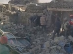Rescue teams stand amid rubble in the aftermath of an earthquake in a location given as Shigatse City, Tibet.