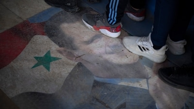Members of ousted Syrian President Bashar Assad's army step on his portrait as they line up to register with newly formed Syrian government as part of an "identification and reconciliation process" in Homs, Syria. (Leo Correa/AP) Members of ousted Syrian President Bashar Assad's army step on his portrait as they line up to register with newly formed Syrian government as part of an "identification and reconciliation process" in Homs, Syria. (Leo Correa/AP)