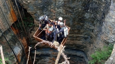 Divers use a pulley to enter a coal mine to rescue trapped miners in Umrangso, a remote area in the northeastern state of Assam (REUTERS)