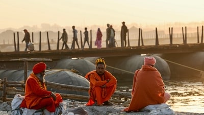 Sadhus rest on the river banks next to a floating pontoon bridge across the river Ganges as they take part in the Juna Akhara procession, ahead of the Maha Kumbh Mela festival in Prayagraj on December 14, 2024 (AFP) Sadhus rest on the river banks next to a floating pontoon bridge across the river Ganges as they take part in the Juna Akhara procession, ahead of the Maha Kumbh Mela festival in Prayagraj on December 14, 2024 (AFP)