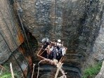 Divers use a pulley to enter the coal mine to rescue trapped miners in Umrangso, a remote area in Assam.
