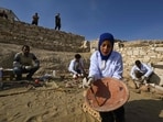 Archaeologists unearth and reassemble pieces of pottery at an intact section of the Queen Hatshepsut Valley Temple's foundations in Deir El-Bahari on the Nile's west bank in Luxor on December 8, 2025, during a media event to announce new discoveries by an Egyptian archaeological expedition.