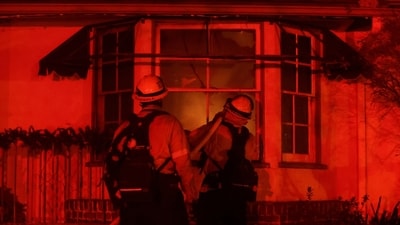 A hose is used from outside the window of a building, as the Eaton Fire burns in Pasadena, California, U.S. January 7, 2025. REUTERS/Mario Anzuoni (REUTERS)