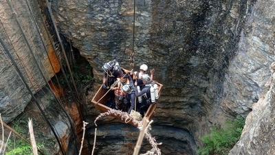 Divers use a pulley to enter the coal mine to rescue trapped miners in Umrangso, a remote area in Assam. (REUTERS)